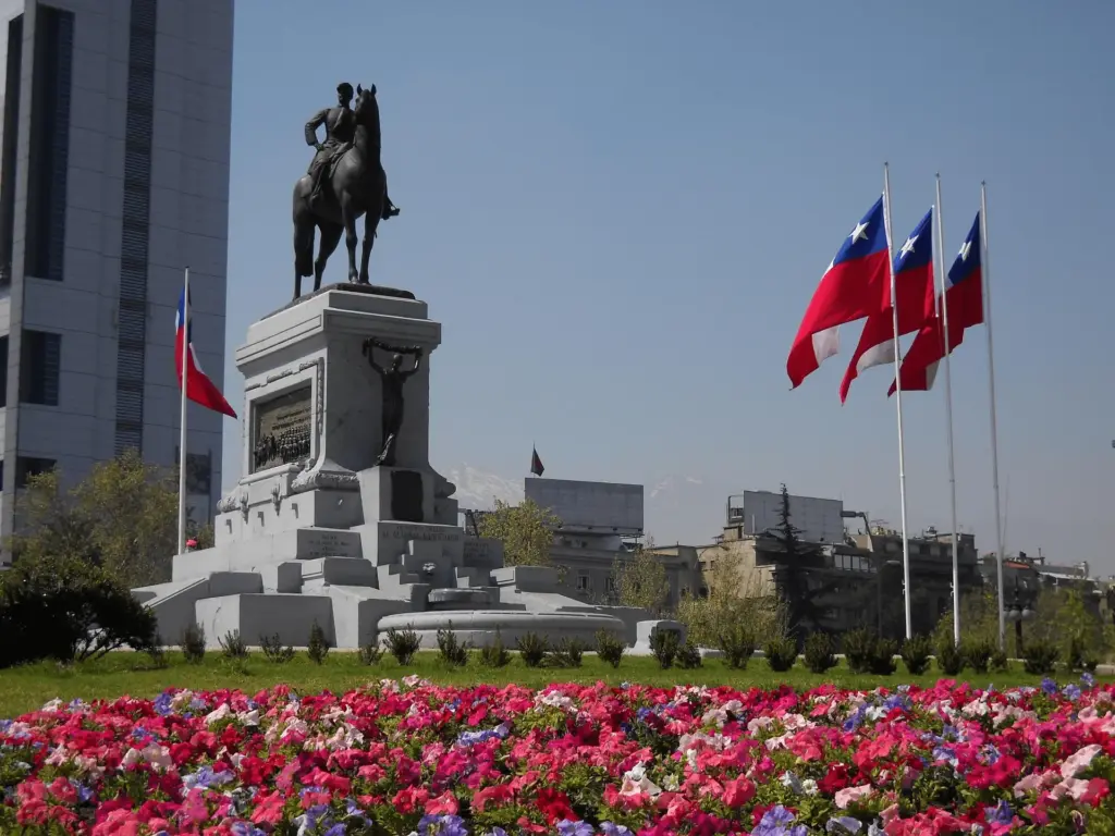 Monumento histórico e bandeiras do Chile em Santiago, capital chilena incluída em pacotes de viagem da KG Viagens.