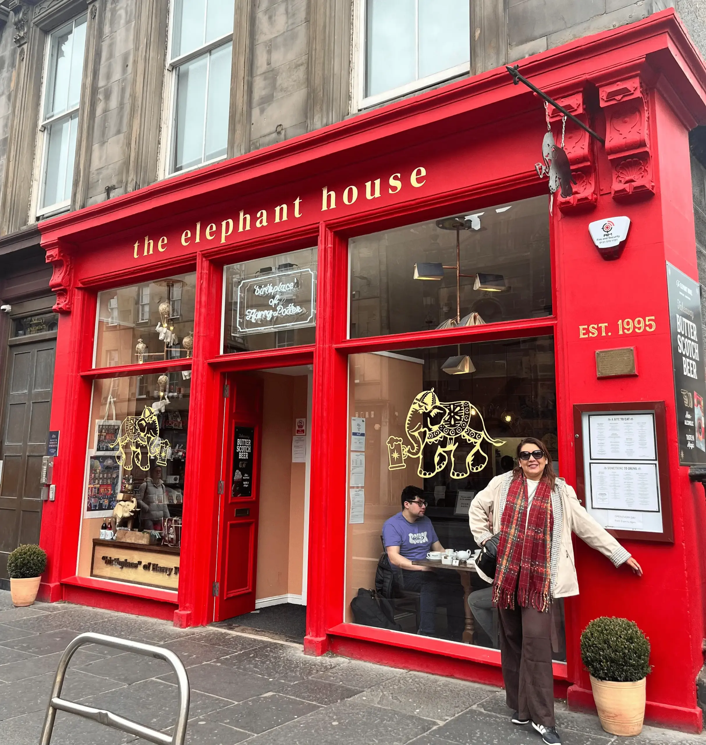 Representante da KG Viagens em frente ao The Elephant House, famoso café associado à criação da série Harry Potter em Edimburgo, Escócia.